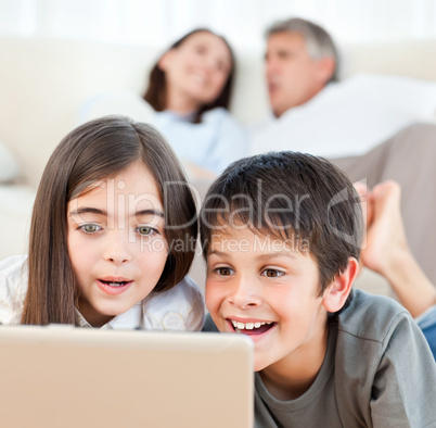 Lovely children watching a movie on their laptop at home