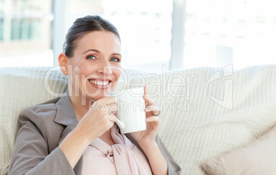 Happy businesswoman drinking a cup of coffee