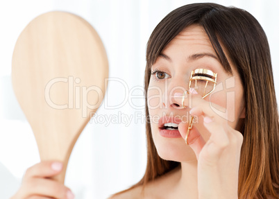 Woman curling her eyelashes