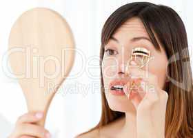 Woman curling her eyelashes