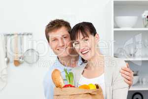 Lovely couple looking at the camera with their shoping bags