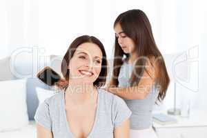 Lovely daughter brushing her woman hair