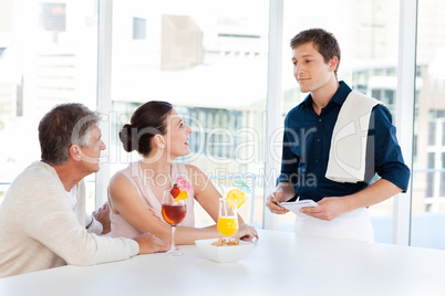 Mature Couple with a waiter in a bar