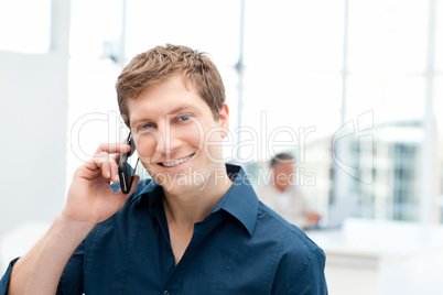 Happy businessman phoning in his office