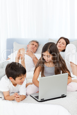 Childrens looking at their laptop while parents are talking