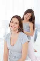 Lovely daughter brushing her woman hair