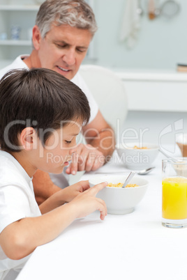 Father having his breakfast with his son