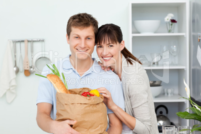 Lovely couple looking at the camera with their shoping bags