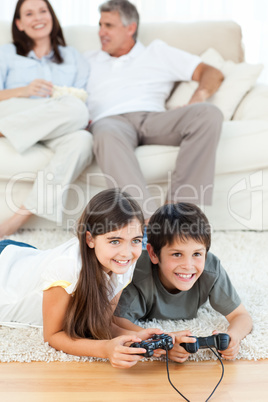 Children playing videogames while parents are talking