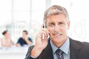 Businessman phoning while his team is working