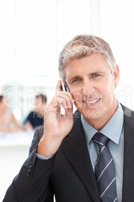 Businessman phoning while his team is working