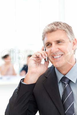 Businessman phoning while his team is working