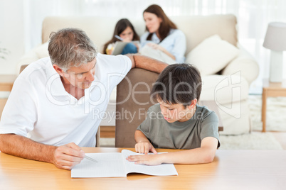 Father helping her son with  his homework