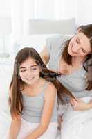 Woman brushing her daughter hair