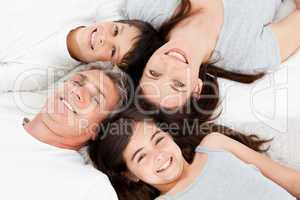Family lying down on their bed