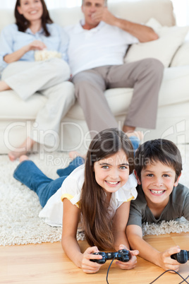 Children playing videogames while parents are talking
