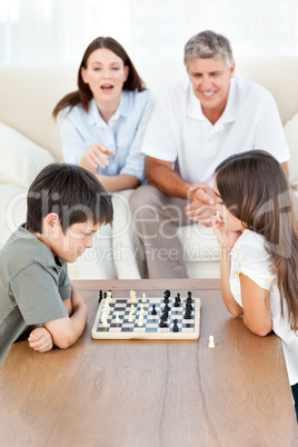 Parents looking their children playing chess