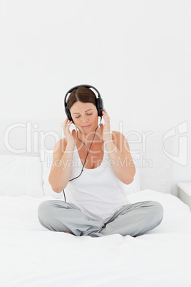 Woman listening to music on her bed