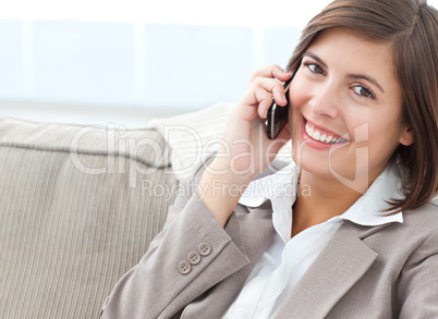 Smilng Businesswoman phoning on her sofa