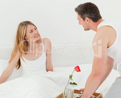 Joyful lovers having breakfast in their bed