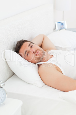 A relaxed man in his bed before waking up