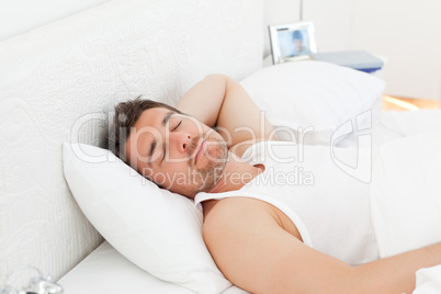 A relaxed man in his bed before waking up