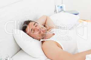 A relaxed man in his bed before waking up
