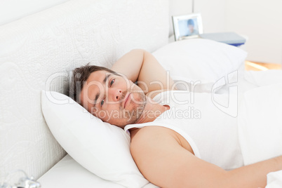 A relaxed man in his bed before waking up