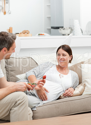 Pregnant woman with her husband eating strawberry