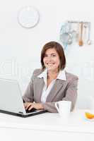 Smiling businesswoman working on her laptop