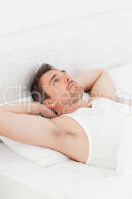 A relaxed man in his bed before waking up