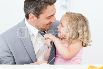 Little girl adjusting the tie of her father