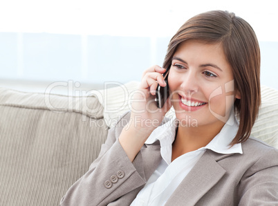 Smilng Businesswoman phoning on her sofa