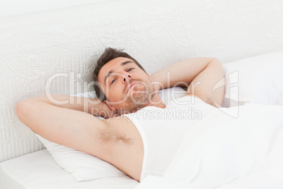 A relaxed man in his bed before waking up