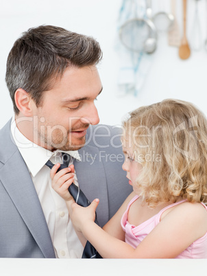 Little girl adjusting the tie of her father