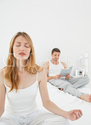 Woman practice yoga while her husband is reading