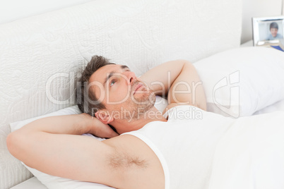 A relaxed man in his bed before waking up