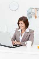 Smiling businesswoman working on her laptop