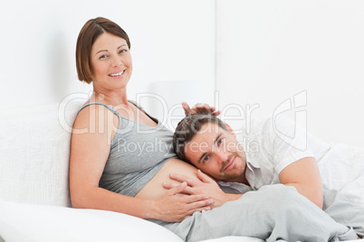 Husband listening to his wife's belly