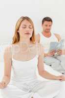 Woman practice yoga while her husband is reading