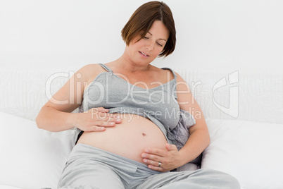 Pregnant woman cuddling her belly