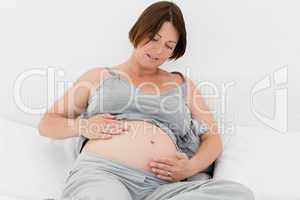 Pregnant woman cuddling her belly