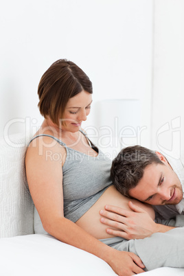 Husband listening to his wife's belly