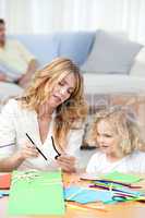 Woman and  her daughter cutting paper