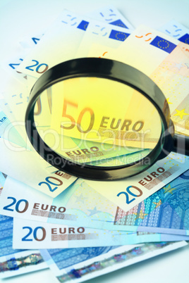 Euro currency under a magnifying glass