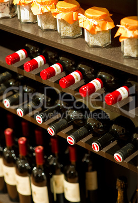 Weinflaschen und Einweckgläser in einem Regal Wine bottles and m