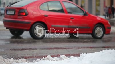 Car driving and people on the snow wet street