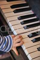 Kinderhand auf Klaviertasten / child's hand on piano keys