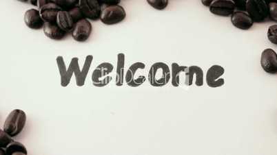 welcome.  written on white under coffee