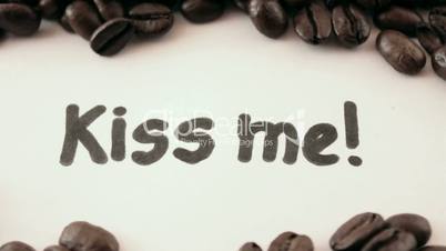 kiss me.  written on white under coffee